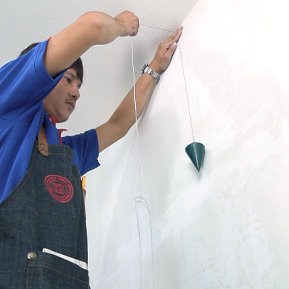 ใช้ลูกดิ่ง วัดตามแนวดิ่งของผนังเพื่อให้ติดวอลเปเปอร์ได้ตรงตามแนว